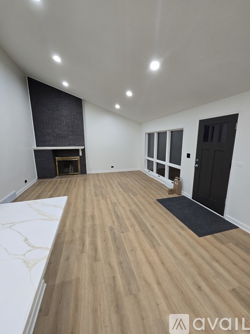 A room with wooden flooring and a black door.