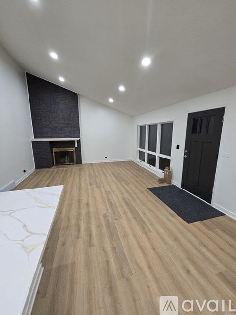 A room with wooden flooring and a black door.