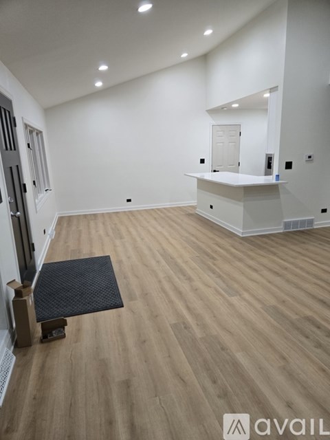 A room with wooden flooring and a white counter.