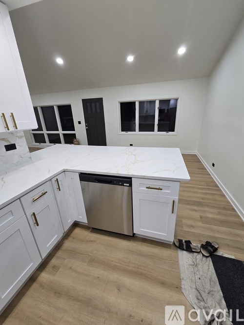 A kitchen with white cabinets and a marble countertop.