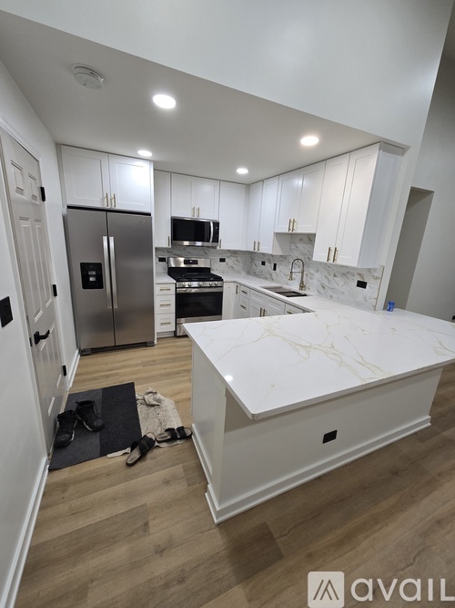 A kitchen with white cabinets and a marble countertop.
