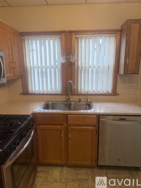 A kitchen with wooden cabinets and a stove top oven.