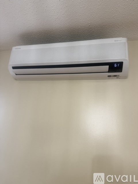 A wall-mounted air conditioner is set to 61 degrees.