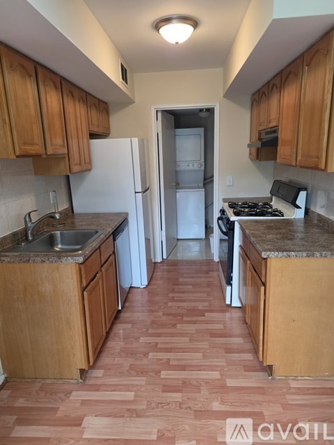 A kitchen with wooden cabinets and a tiled floor.