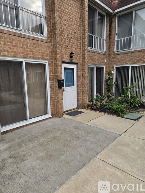 A brick building with a white door and a small garden in front.