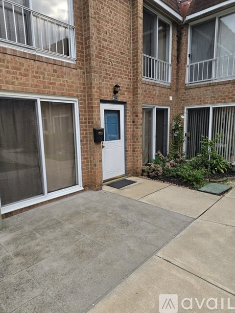 A brick building with a white door and a small garden in front.