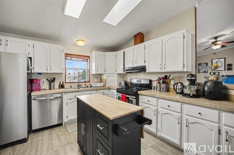A kitchen with white cabinets and a wooden island.