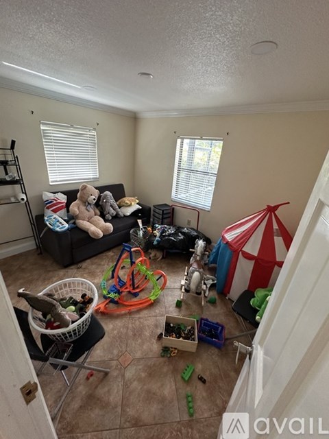 A living room with a couch, toys, and a circus tent.