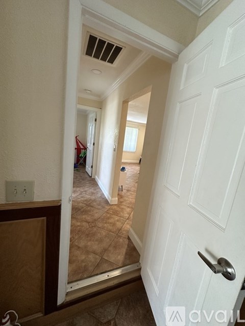 A hallway with a white door and a brown floor.