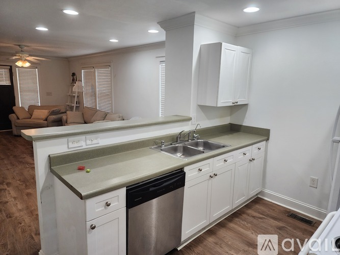 A kitchen with white cabinets and a stainless steel dishwasher.