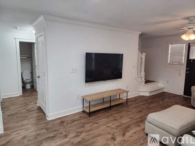 A living room with a television and a bench.