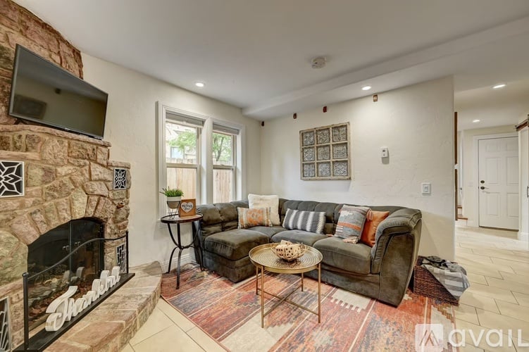 A living room with a stone fireplace and a couch.