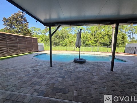 A pool with a black umbrella and a black pole.