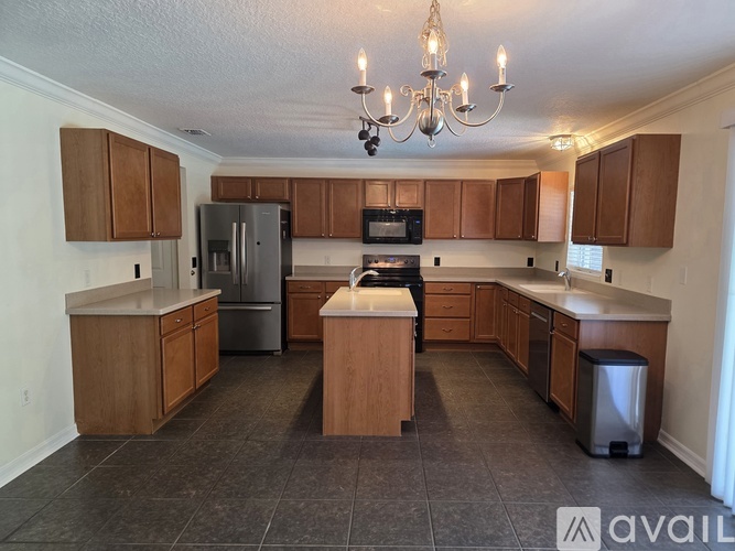 A kitchen with wooden cabinets and a chandelier.