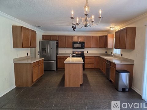 A kitchen with wooden cabinets and a chandelier.