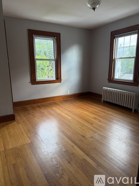A room with wooden floors and two windows.