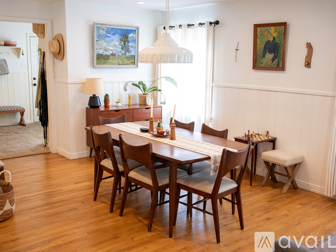 A dining room with a wooden table and chairs.