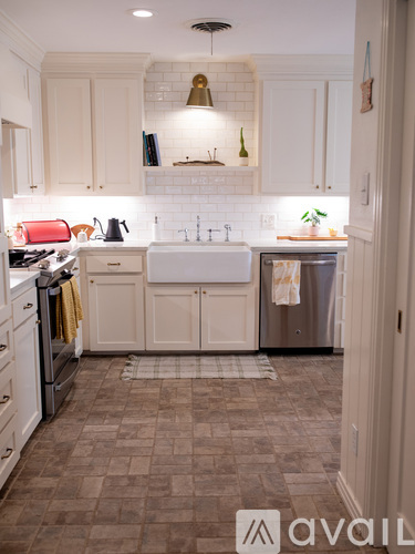 A kitchen with white cabinets and a tiled floor.
