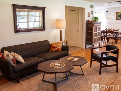 A living room with a dark sofa, a coffee table, and a lamp.