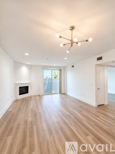 A large, empty room with wooden floors and a chandelier.
