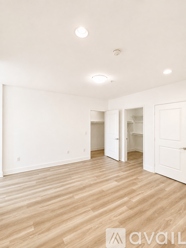 A room with wooden flooring and white walls.