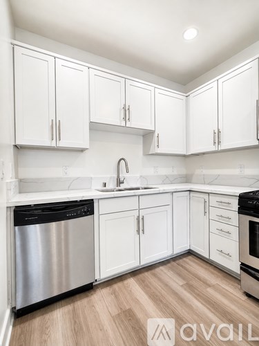 A kitchen with white cabinets and a stainless steel dishwasher.