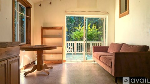 A living room with a couch, table, and sliding glass doors.