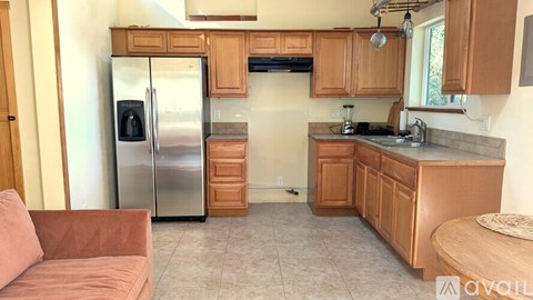 A kitchen with wooden cabinets and a refrigerator.