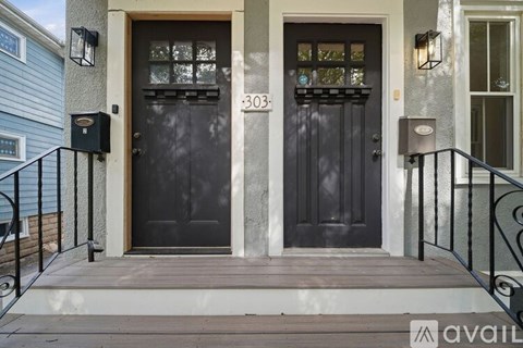 The front door of a house numbered 303 is black with a glass panel.