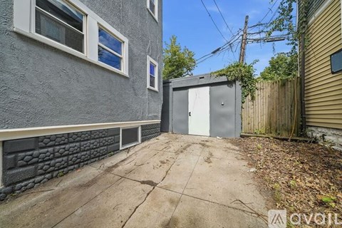 A grey building with a grey door and a window.