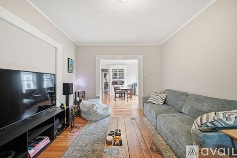 A living room with a grey couch and a black television.