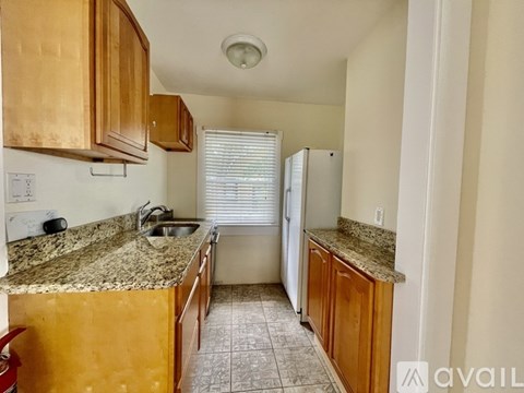 A kitchen with wooden cabinets and granite countertops.
