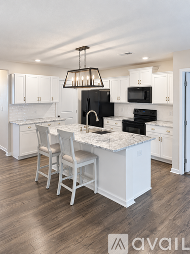 A kitchen with white cabinets and a marble countertop.