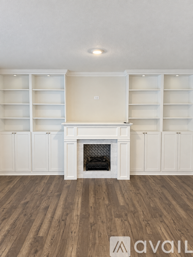 A living room with a fireplace and built-in shelves.