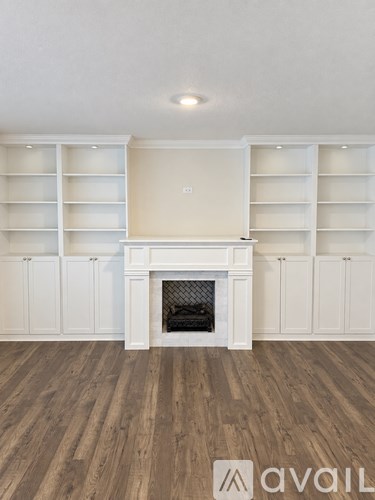 A living room with a fireplace and built-in shelves.