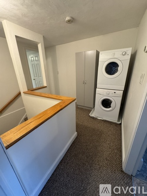 A small laundry room with a washer and dryer stacked on top of each other.