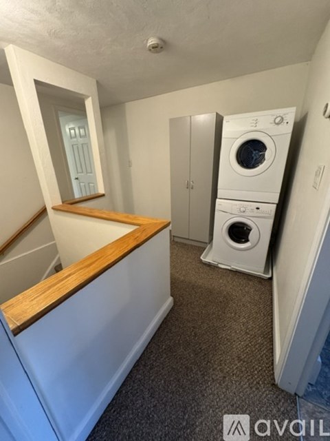A small laundry room with a washer and dryer stacked on top of each other.