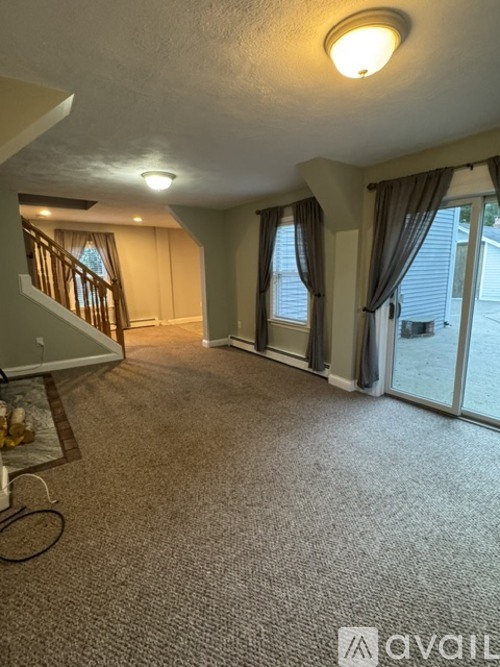 A living room with a carpeted floor and a television.