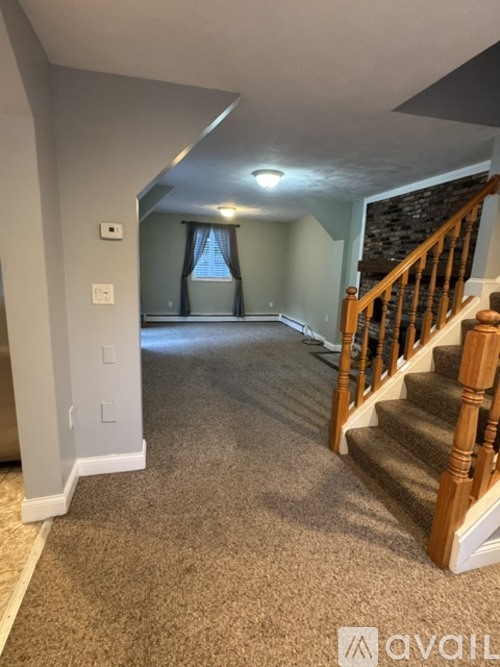 A hallway with a staircase leading to the second floor.