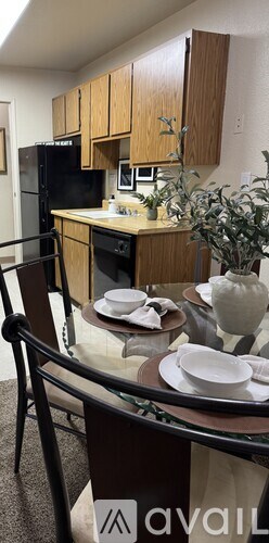 A kitchen with wooden cabinets and a black refrigerator.