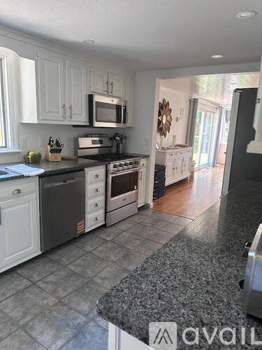 A kitchen with granite countertops and white cabinets.