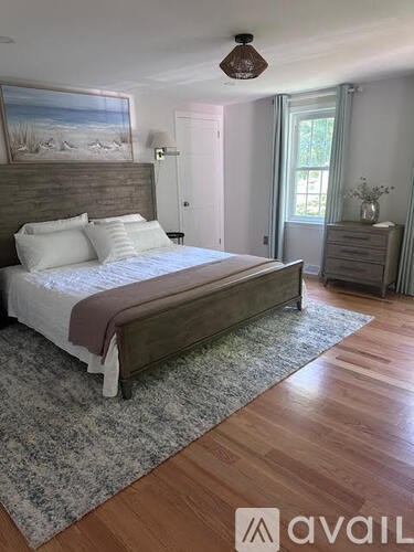 A bedroom with a large bed and a ceiling fan.