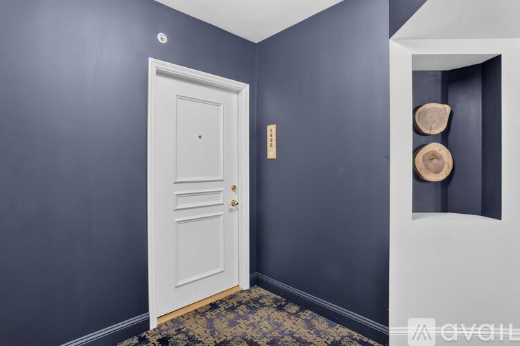 A white door with a gold handle is in a room with dark blue walls.