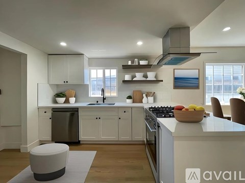 A modern kitchen with a large island and stainless steel appliances.