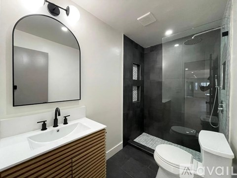 A modern bathroom with a white sink and a large mirror.
