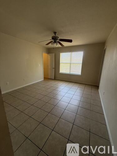 A room with a ceiling fan and tile flooring.