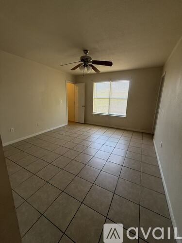 A room with a ceiling fan and tile flooring.
