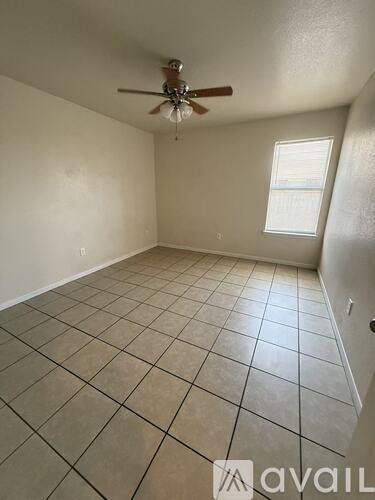 A room with a ceiling fan and a window.