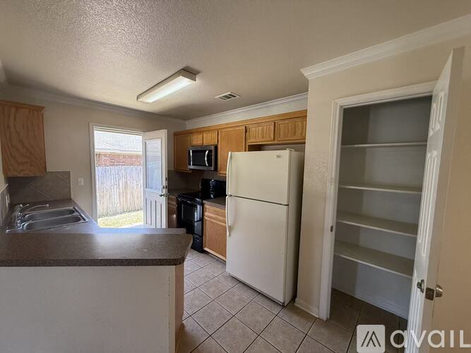 A kitchen with a white refrigerator and wooden cabinets.