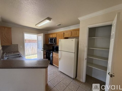 A kitchen with a white refrigerator and wooden cabinets.